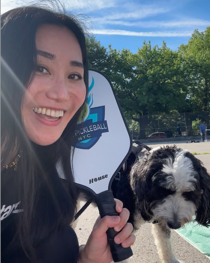 Kaori Rei smiling outdoors with her dog