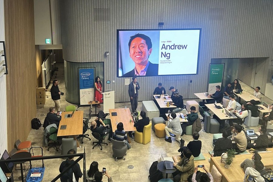 Full room view of the DeepLearning.AI Builder Night at Google for Startups Campus Tokyo, with Andrew Ng featured on screen